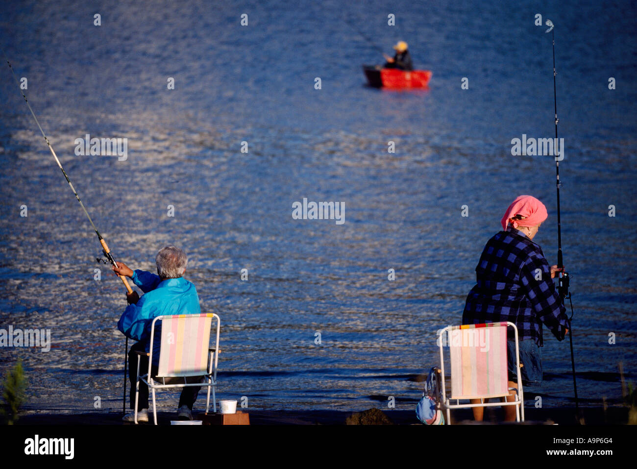 Senior Couple fishing from Shore in Fraser River, New Westminster, BC, British Columbia, Canada - Fisherman fishes from Rowboat Stock Photo