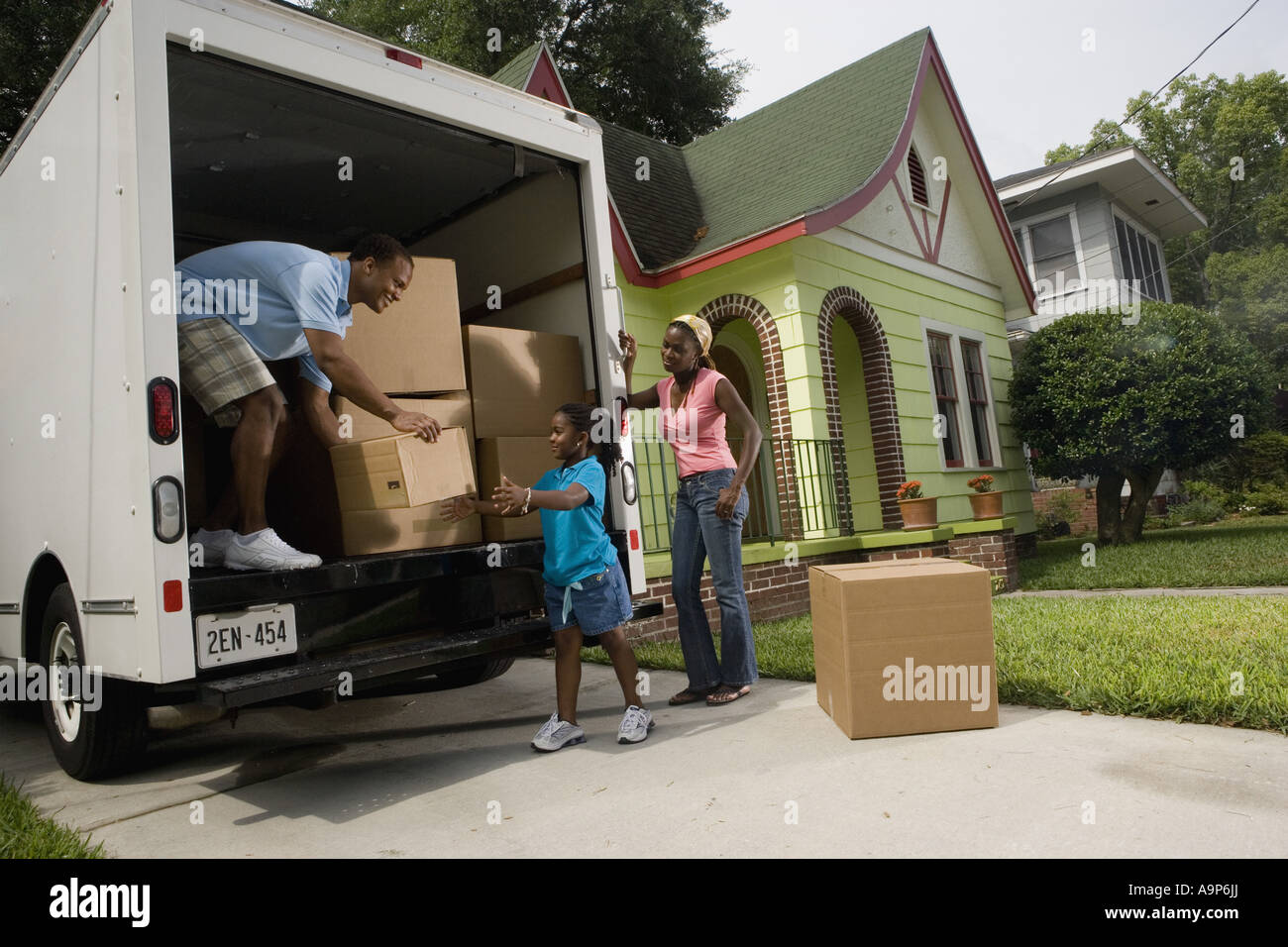 Family unloading boxes from moving truck Stock Photo - Alamy