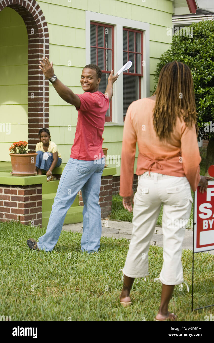 Family outside house with For Sale sign Stock Photo - Alamy