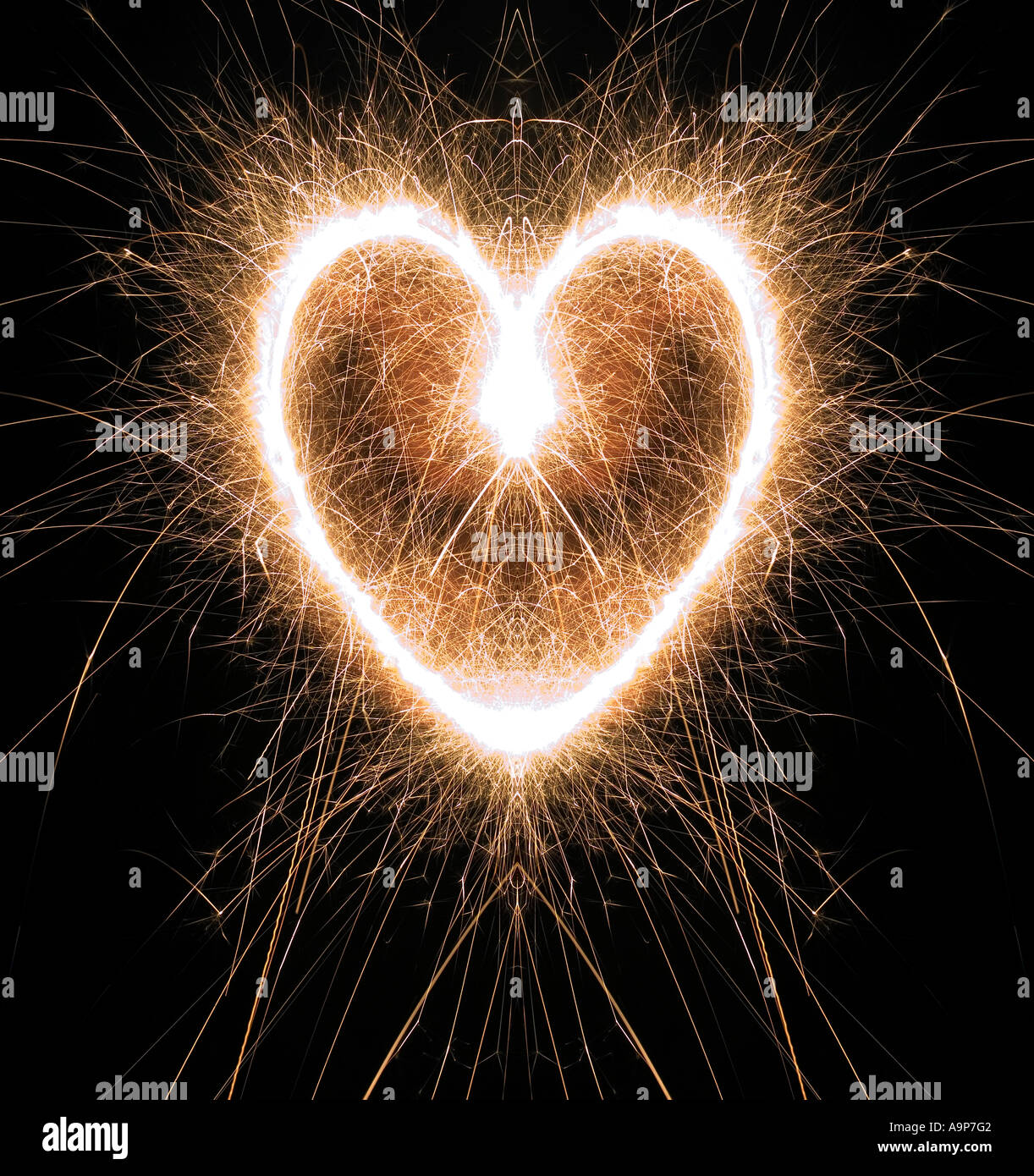 Sparkling heart shape made at night with sparklers Stock Photo