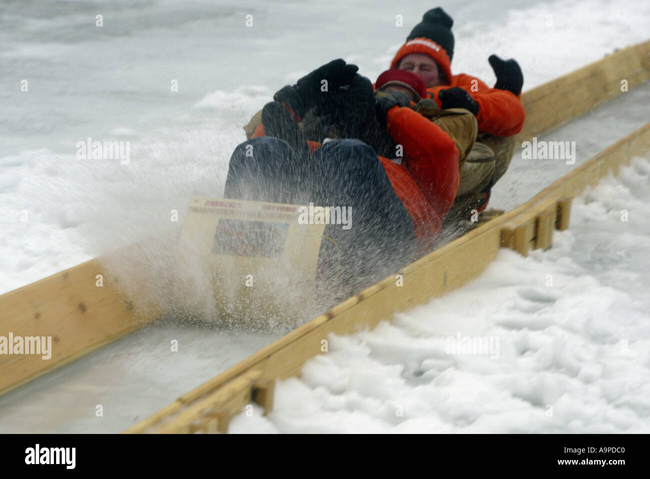 Sledders coming down a toboggan chute Stock Photo Alamy