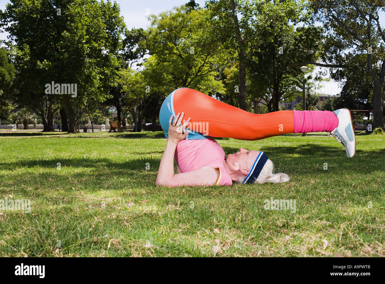 Senior adult woman stretching in the park Stock Photo