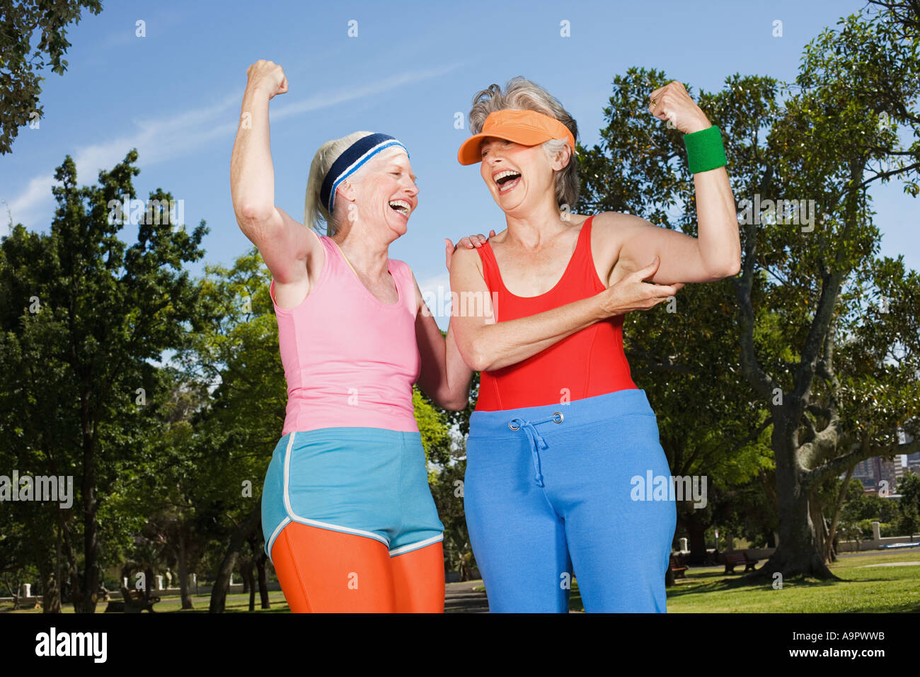 Two senior adult women exercising in park Stock Photo