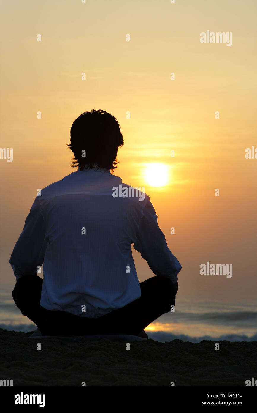 Rear view of a man sitting on a beach Stock Photo - Alamy