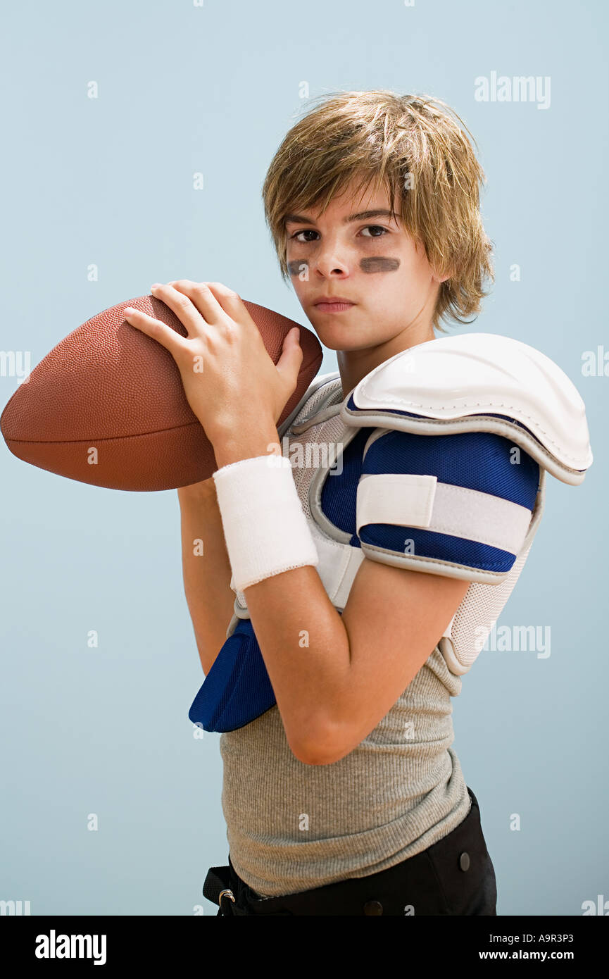 Boy in american football uniform holding ball Stock Photo Alamy