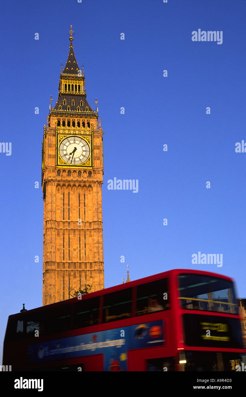 Red London Bus passing Big Ben on a clear day, London, UK Stock Photo