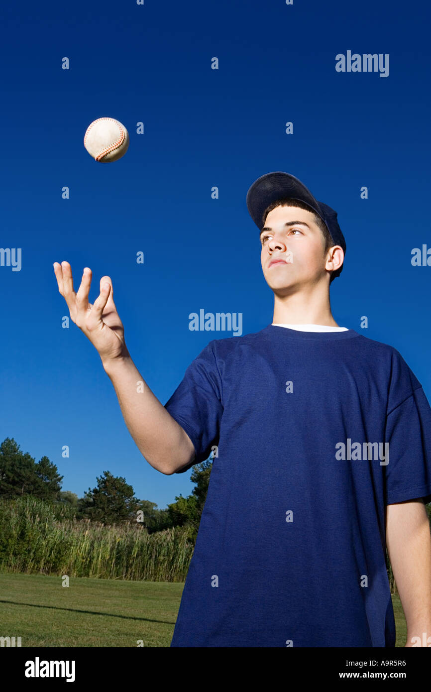 Teenage boy throwing baseball in the air Stock Photo Alamy