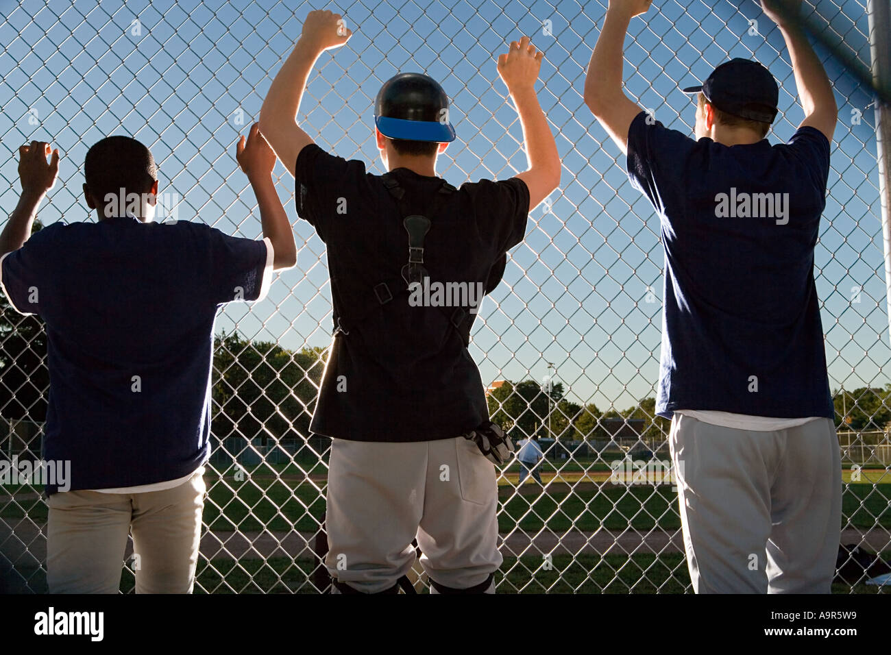 Three teenagers watching from the sidelines Stock Photo - Alamy
