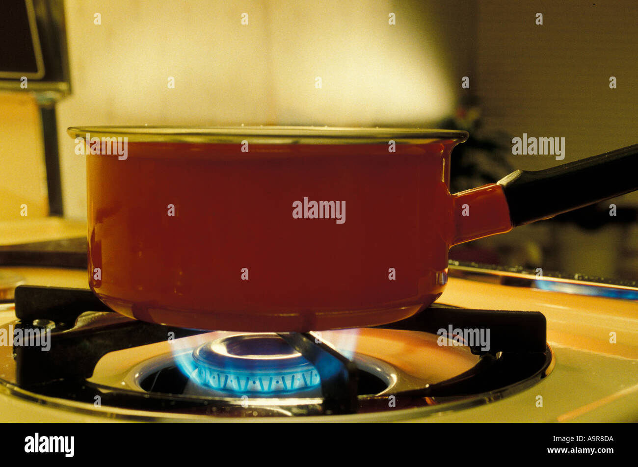 A pan of boiling water on a stove - gas flame - steam Stock Photo