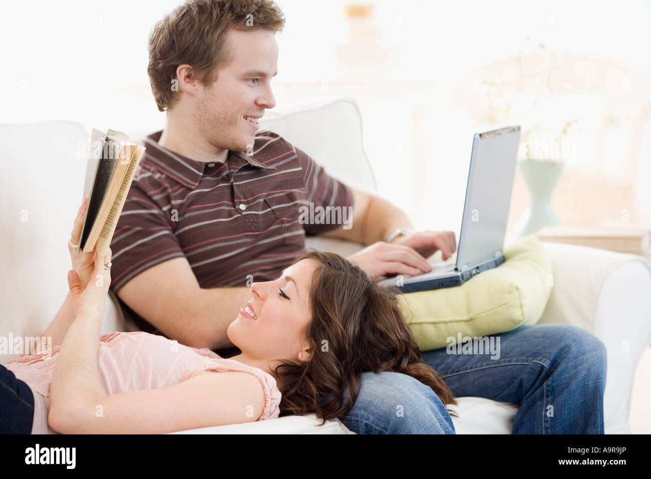 Couple relaxing on sofa Stock Photo - Alamy