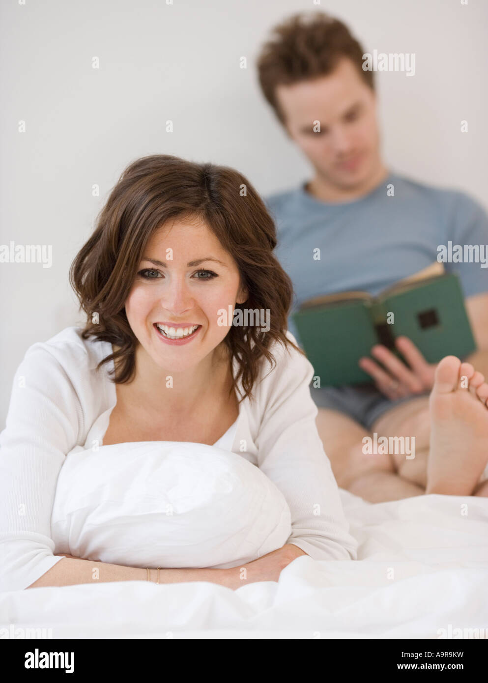 Couple relaxing in bed Stock Photo Alamy