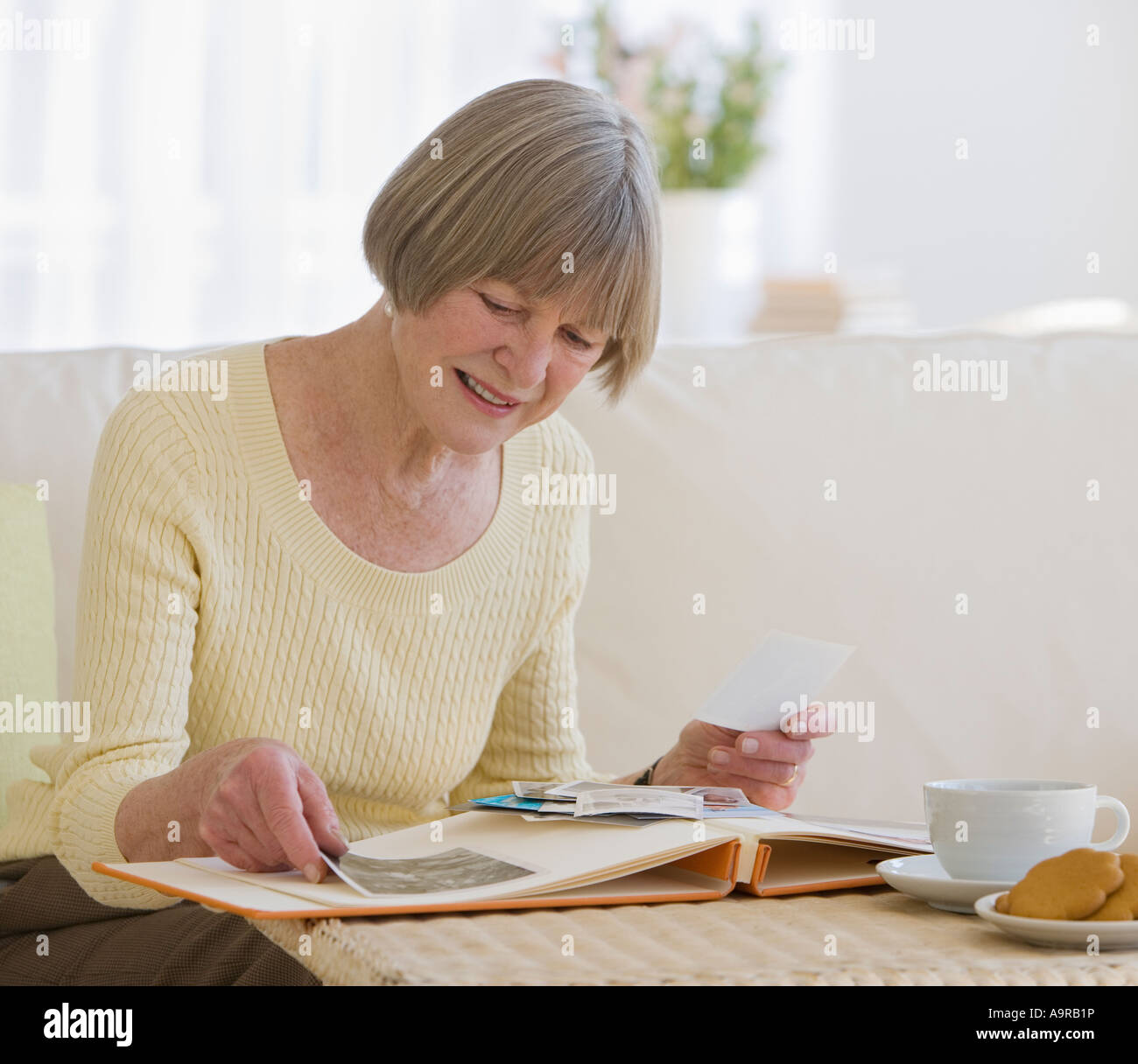 Senior woman looking at photo album Stock Photo