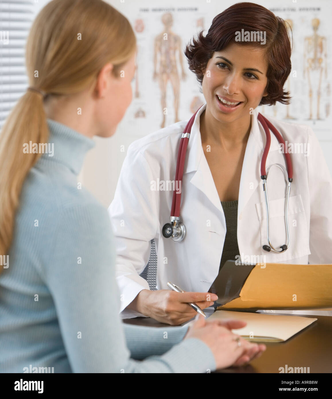 Female doctor talking to woman in office Stock Photo - Alamy