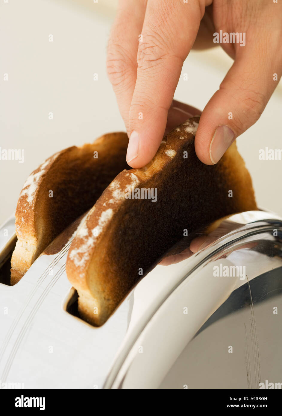 Man taking toast out of toaster Stock Photo Alamy