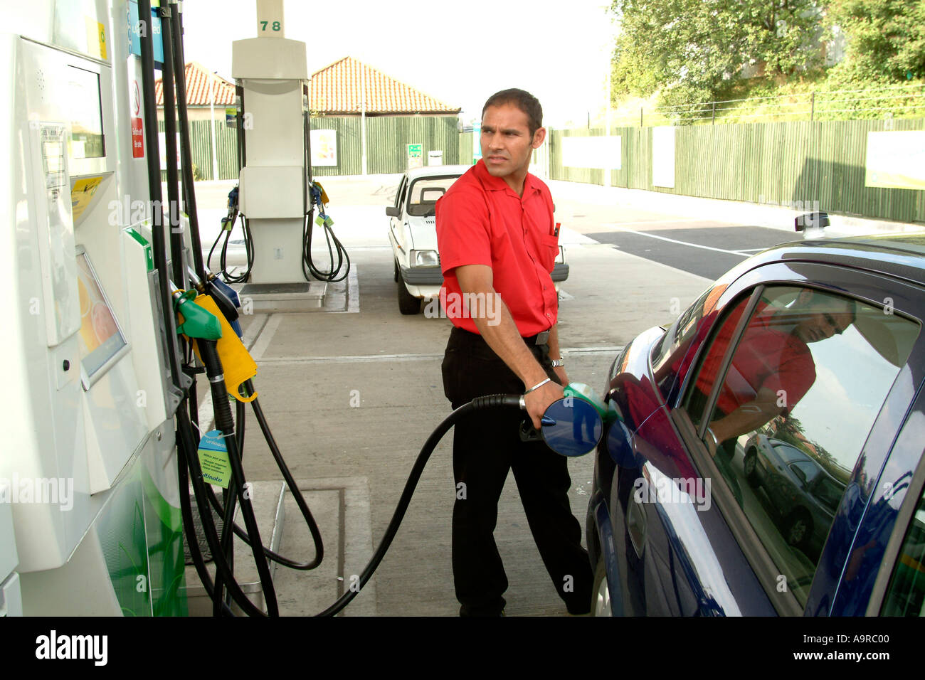 Man filling his car with petrol at a filling station, Hampton, UK Stock