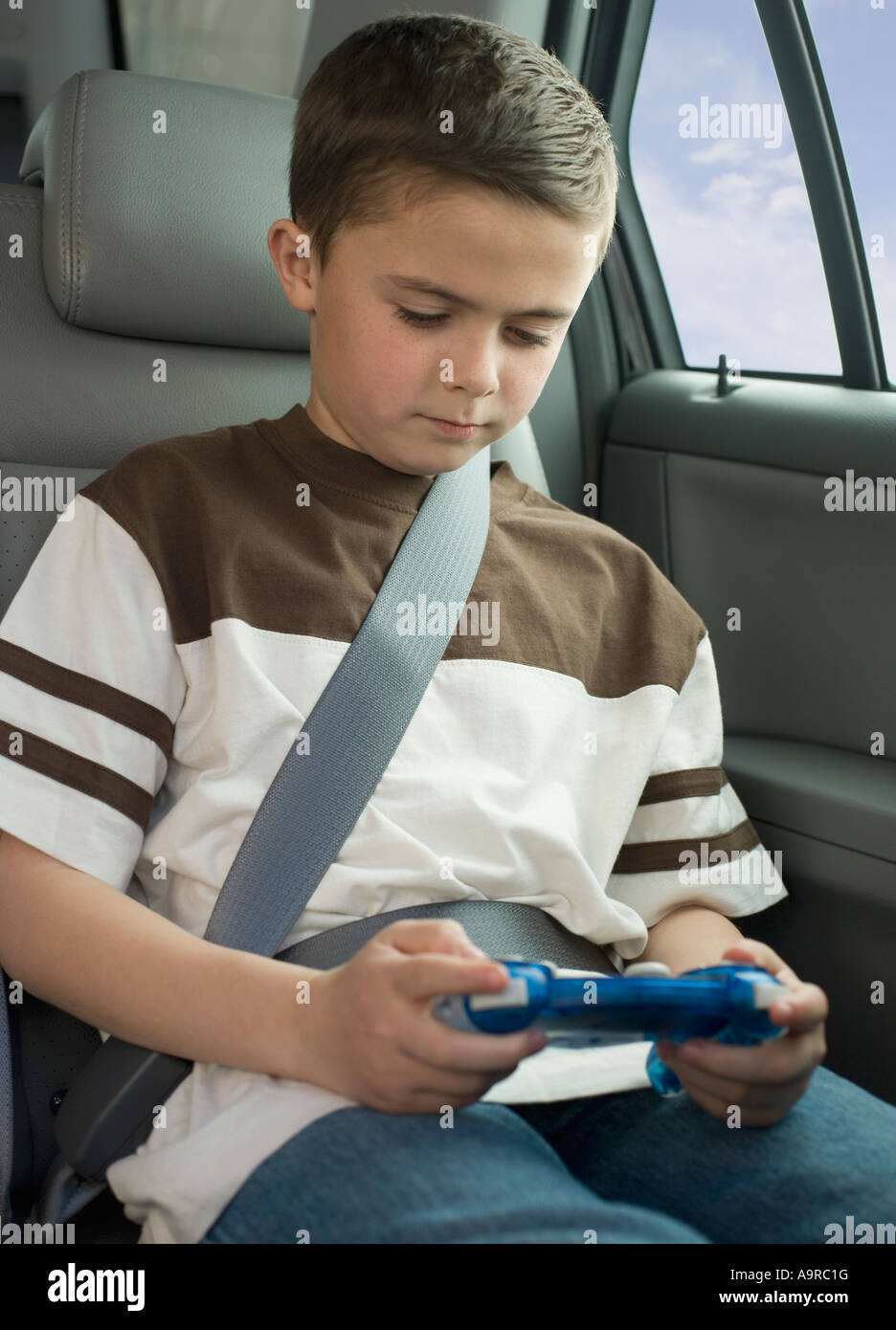 Boy playing video game in car Stock Photo Alamy