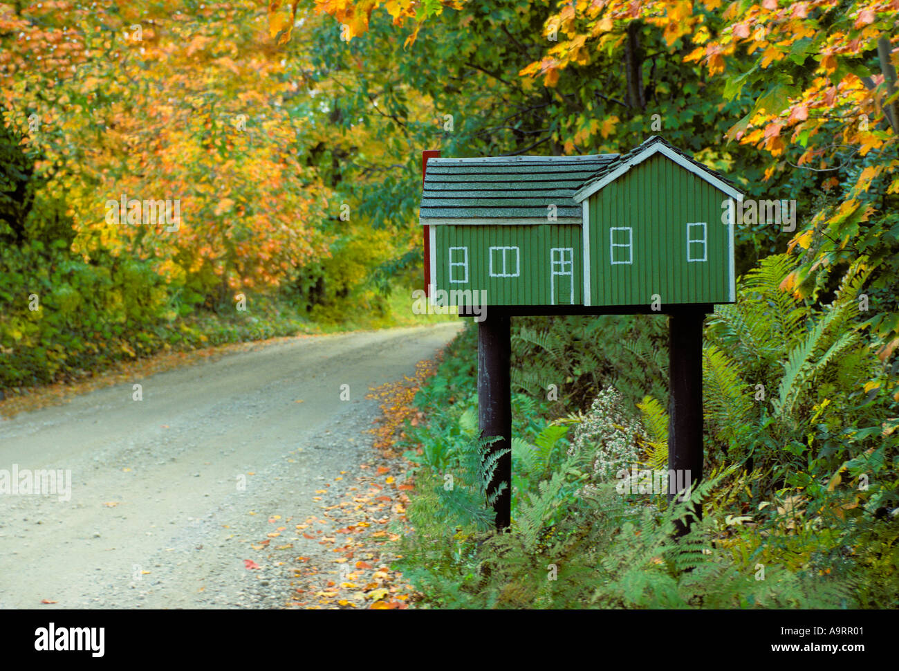 Small model house built as mailbox standing by a lone country road Stock Photo