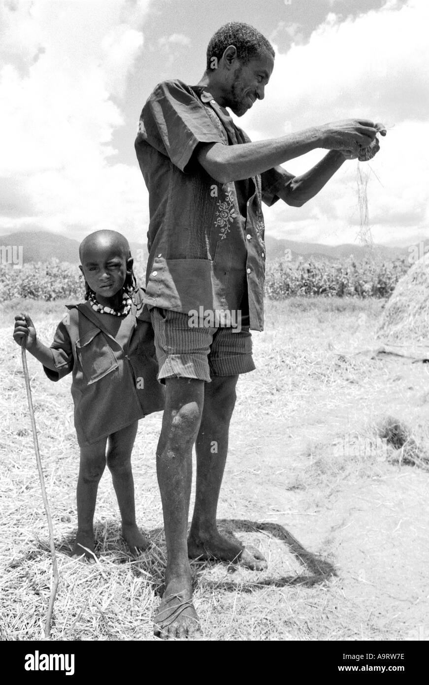 B/W of a farmer, with his young son, hand-winnowing teff to make traditional injera. Mekoni, Tigray, Ethiopia, Africa Stock Photo
