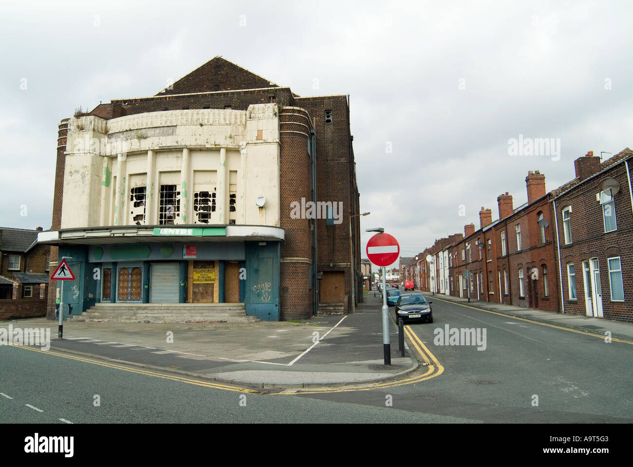 Old disused cinema and bingo hall next to terraced housing in Newton le Willows near St Helens in Merseyside. Stock Photo