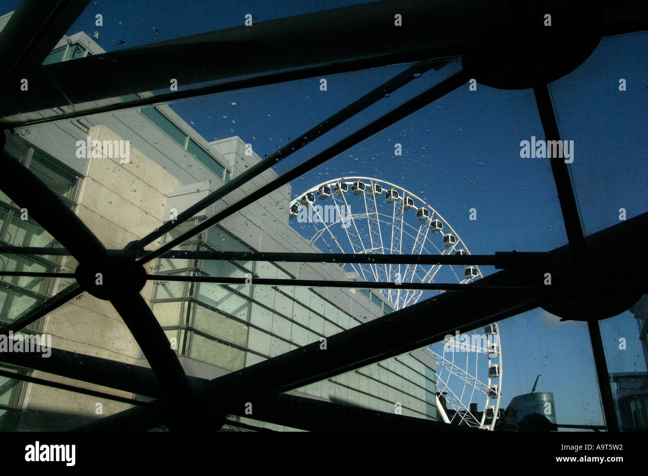 Manchester ferris wheel through a pedestrian bridge in the UK Stock