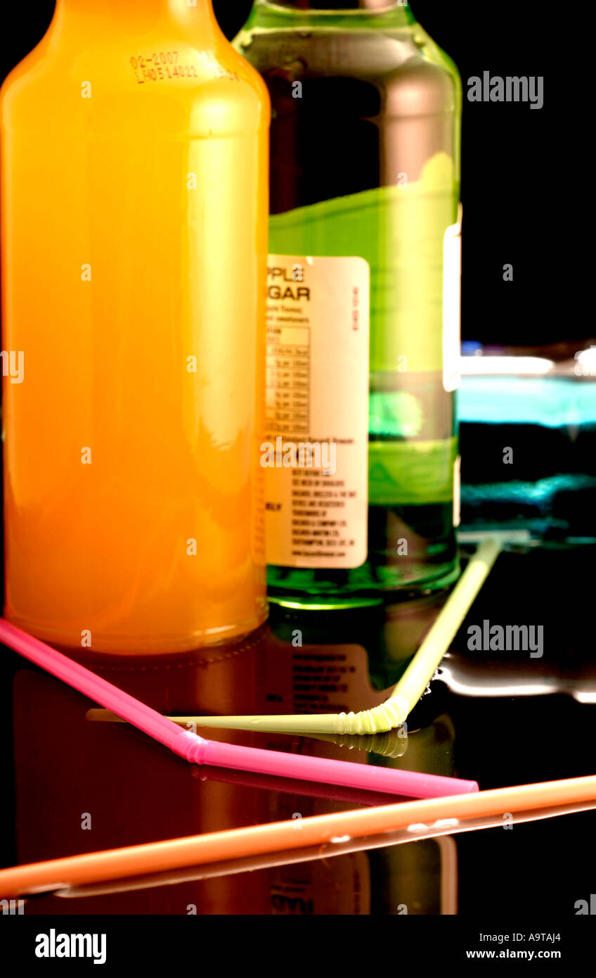 A selection of various alcopops with straws reflected on surface Stock Photo