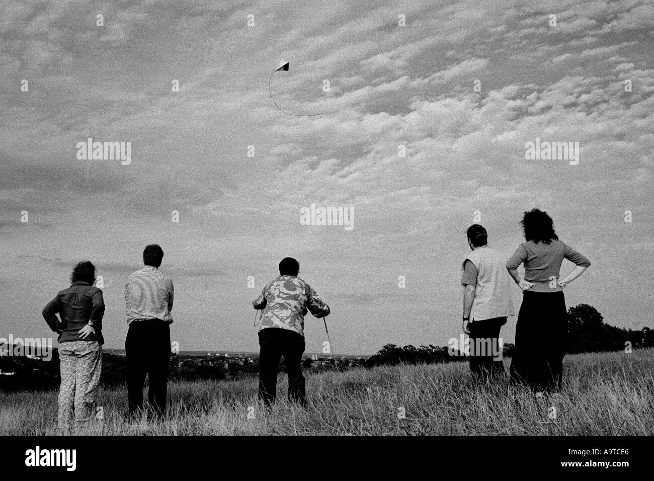 5 people watching kite flying Stock Photo Alamy