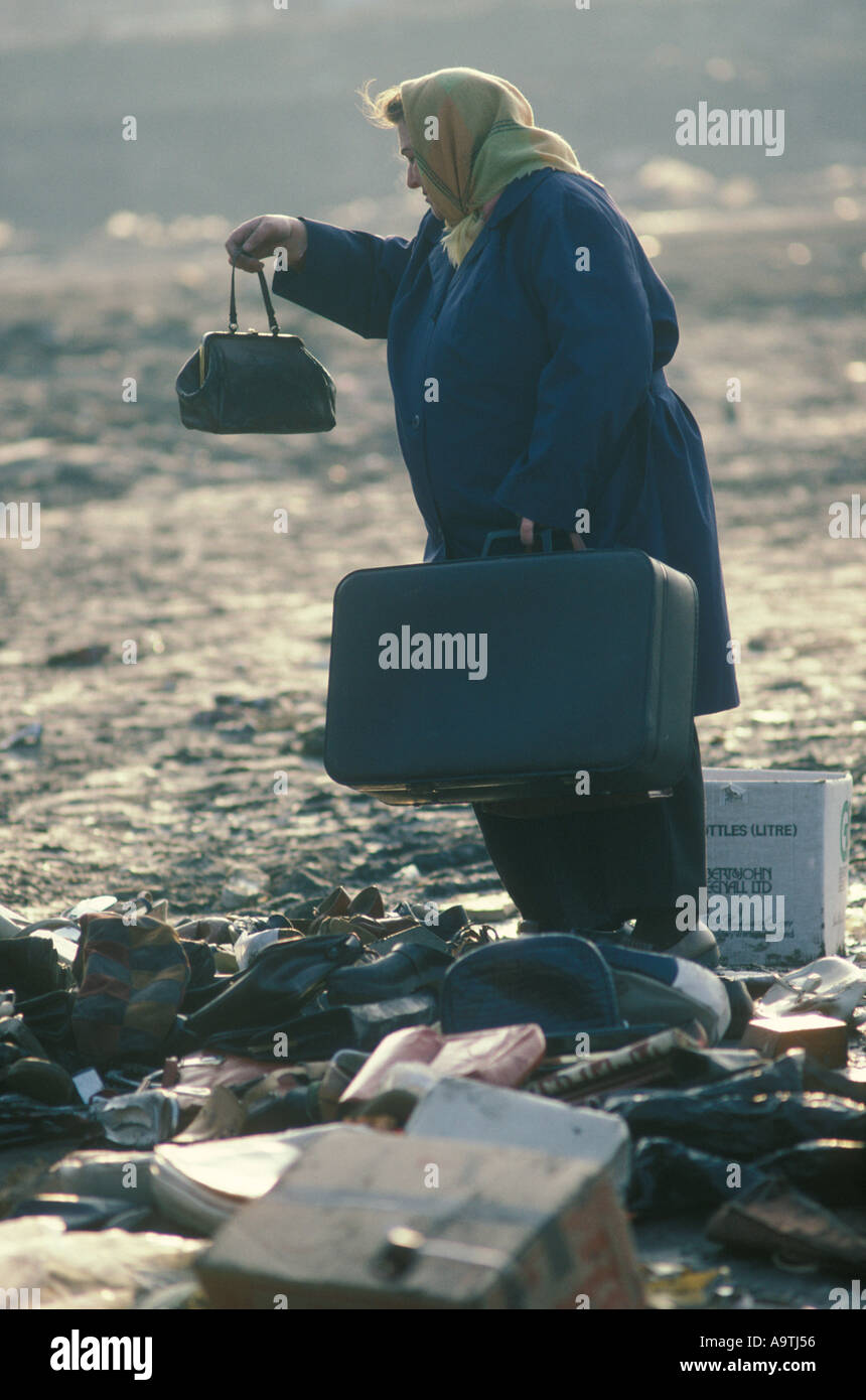Poverty Uk 1980s. Woman inspects a cast off hand bag and suitcase at end of flea market, on a slum clearance site Everton Liverpool 1983 HOMER SYKES Stock Photo