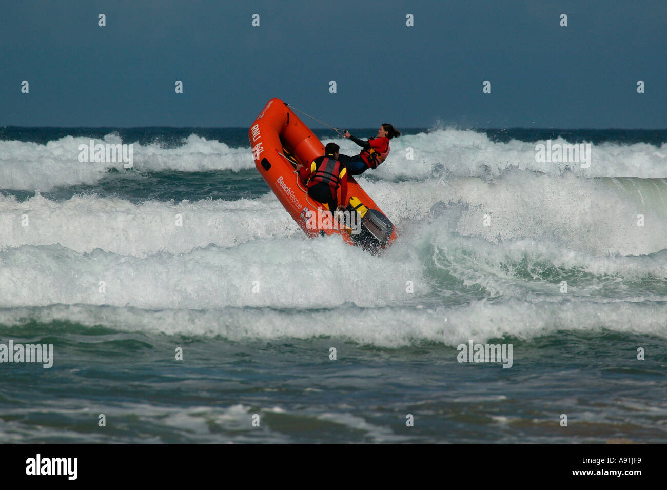 Life guards in rough seas in dinghy off Perranporth Beach Stock Photo