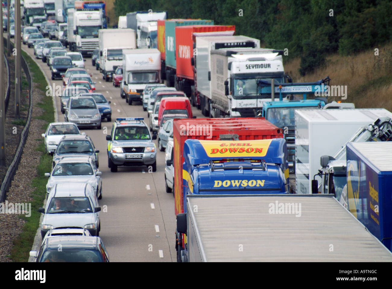 M25 Motorway three lanes of queuing traffic police car on emergency call trying to progress Stock Photo