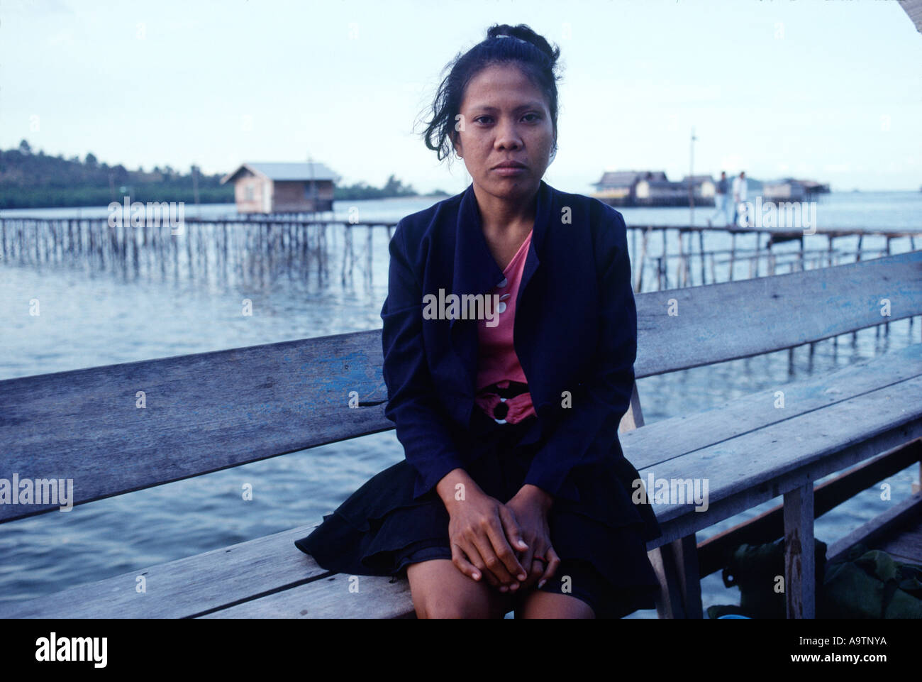 Belakangpadang, Indonesia: Lashmi,  wife of a man charged with piracy, waits to hear what will happen to him. Stock Photo