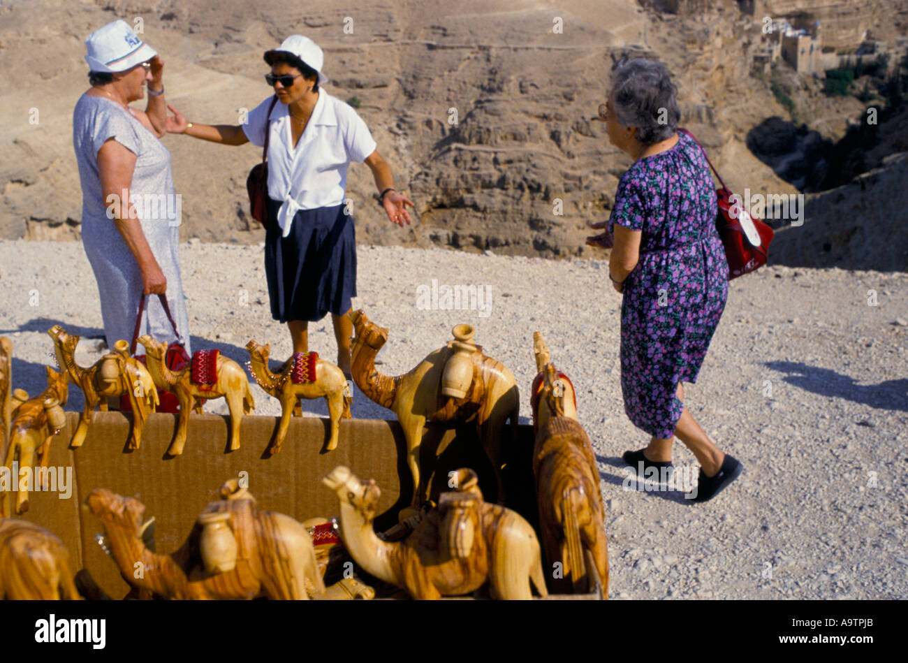 Tourists on a coach tour from Jerusalem pass souvenir sellers on their way to visit the Monestary of St George Stock Photo