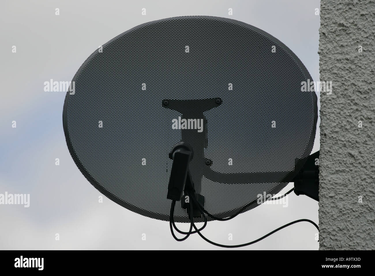 Satellite dish attached to side of house Stock Photo