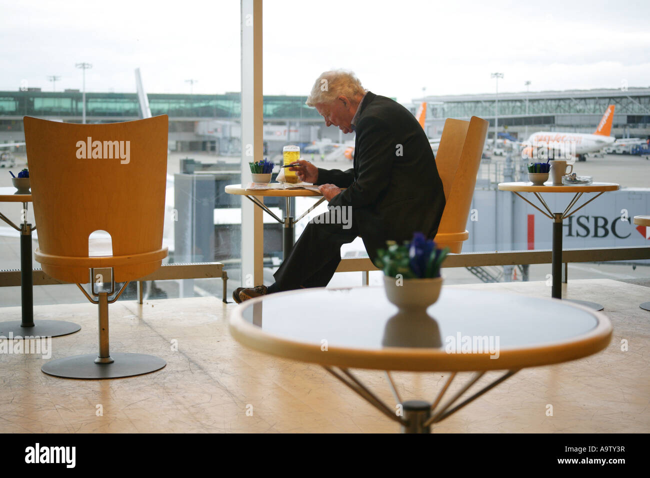 Traveller in departure lounge cafe, Stansted airport, Essex, England, UK. EDITORIAL USE ONLY Stock Photo