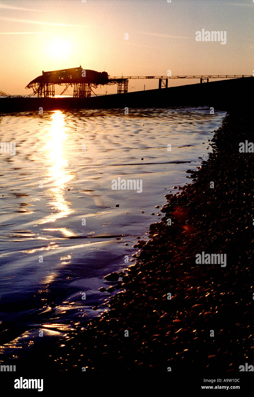Sun refecting off water at sunset with famous Brighton West Pier ...