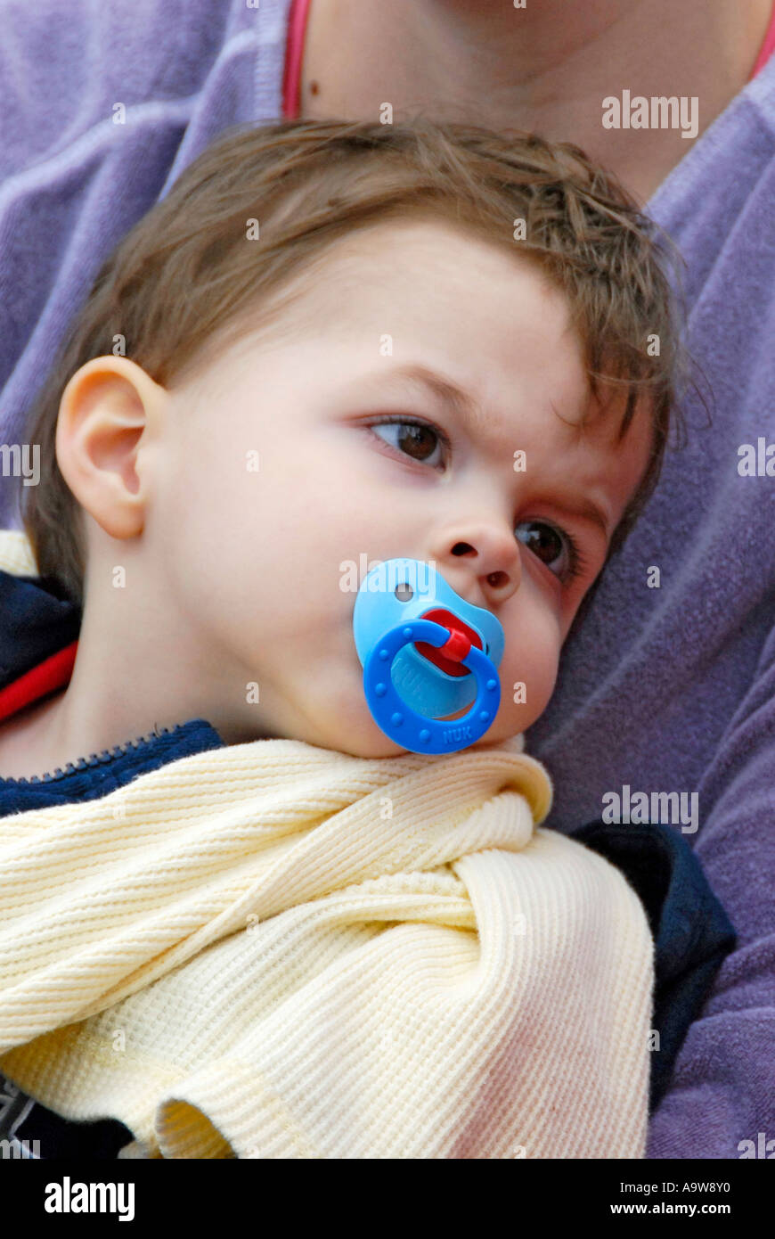 Tired sleepy baby child with pacifier in his mouth Stock Photo Alamy