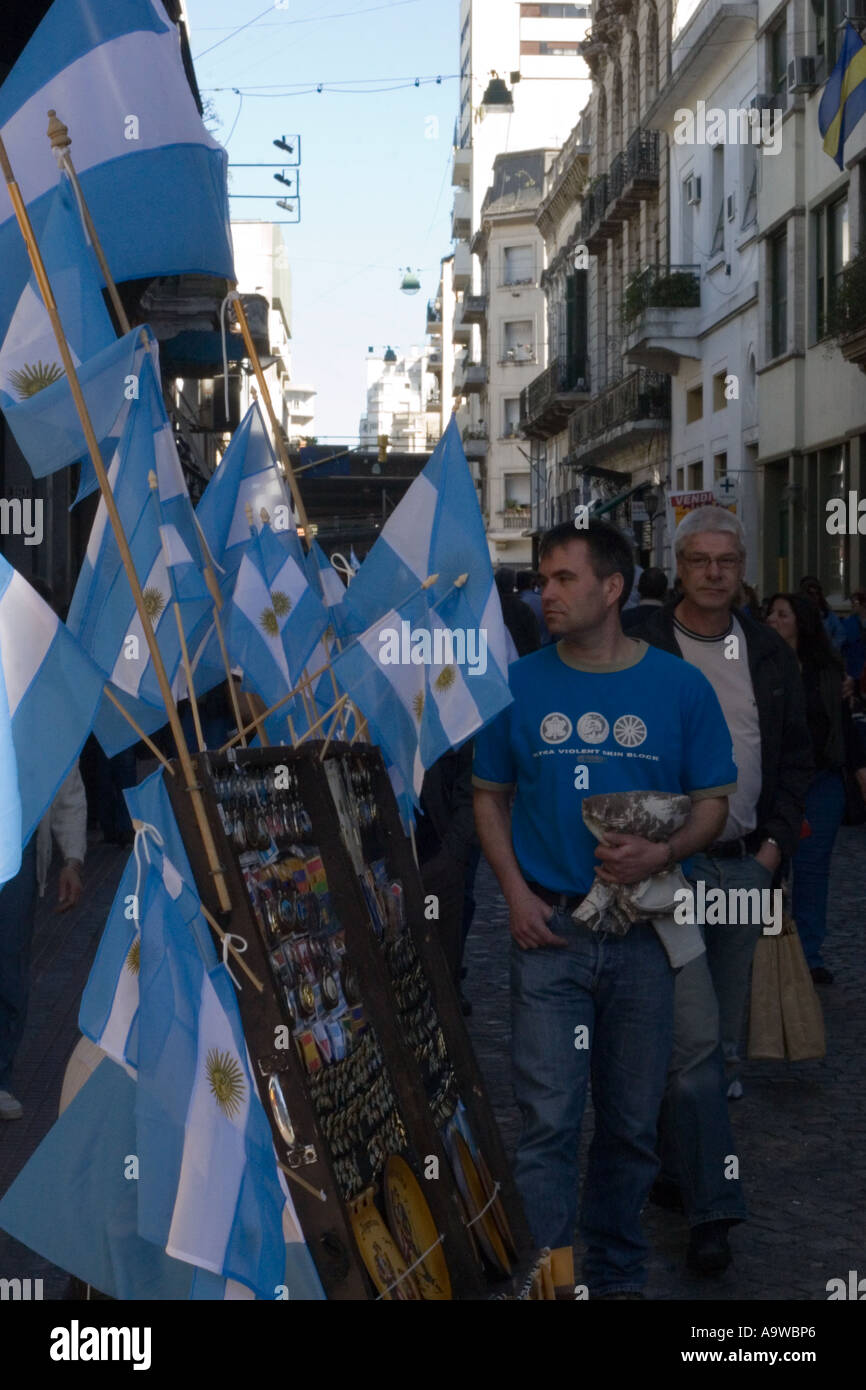 Local men walking past a stall selling Argentinian flags Stock Photo
