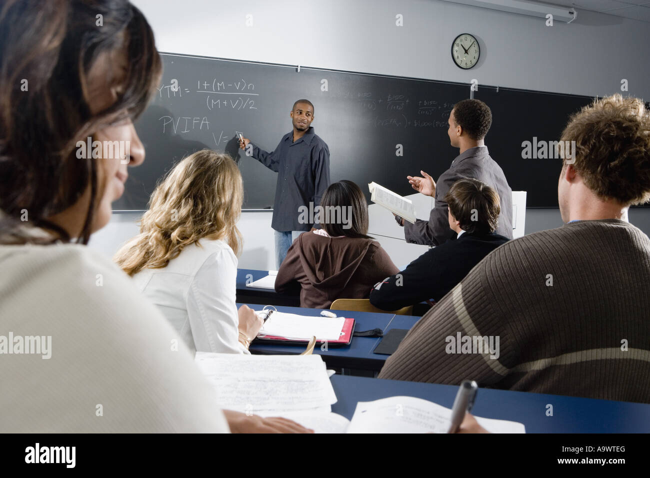 Teacher teaching students in the classroom Stock Photo - Alamy