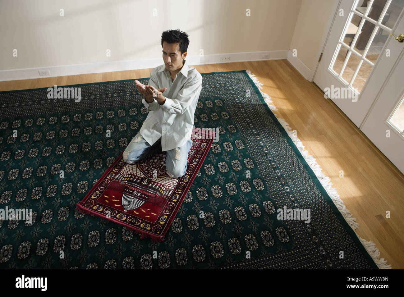 A Muslim man praying on a prayer mat Stock Photo Alamy