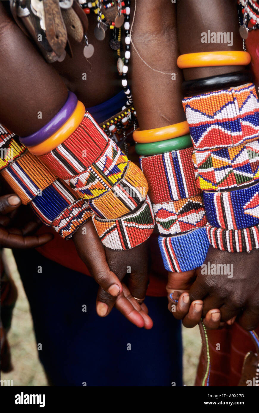 Lolgorian, Kenya. Siria Maasai Manyatta; moran warriors holding hands with brightly coloured bead bracelets. Stock Photo