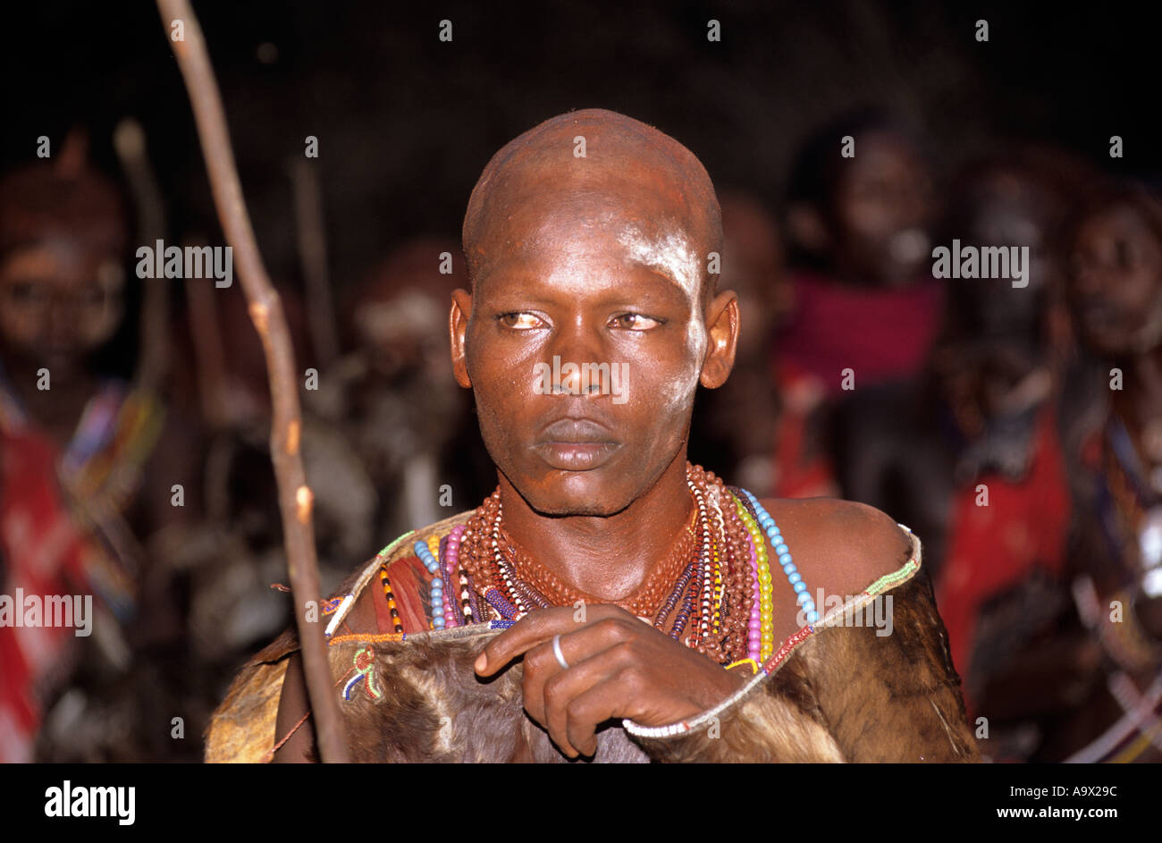 Lolgorian, Kenya. Siria Maasai Manyatta; newly shaved moran wearing ceremonial cowhide cloak looking sad and serious. Stock Photo