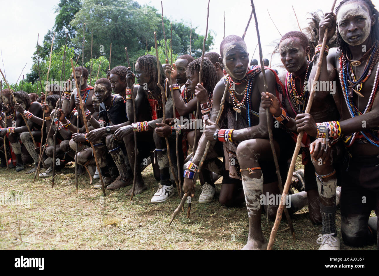 Lolgorian, Kenya. Siria Maasai; Eunoto ceremony; line of kneeling moran with white ochre body