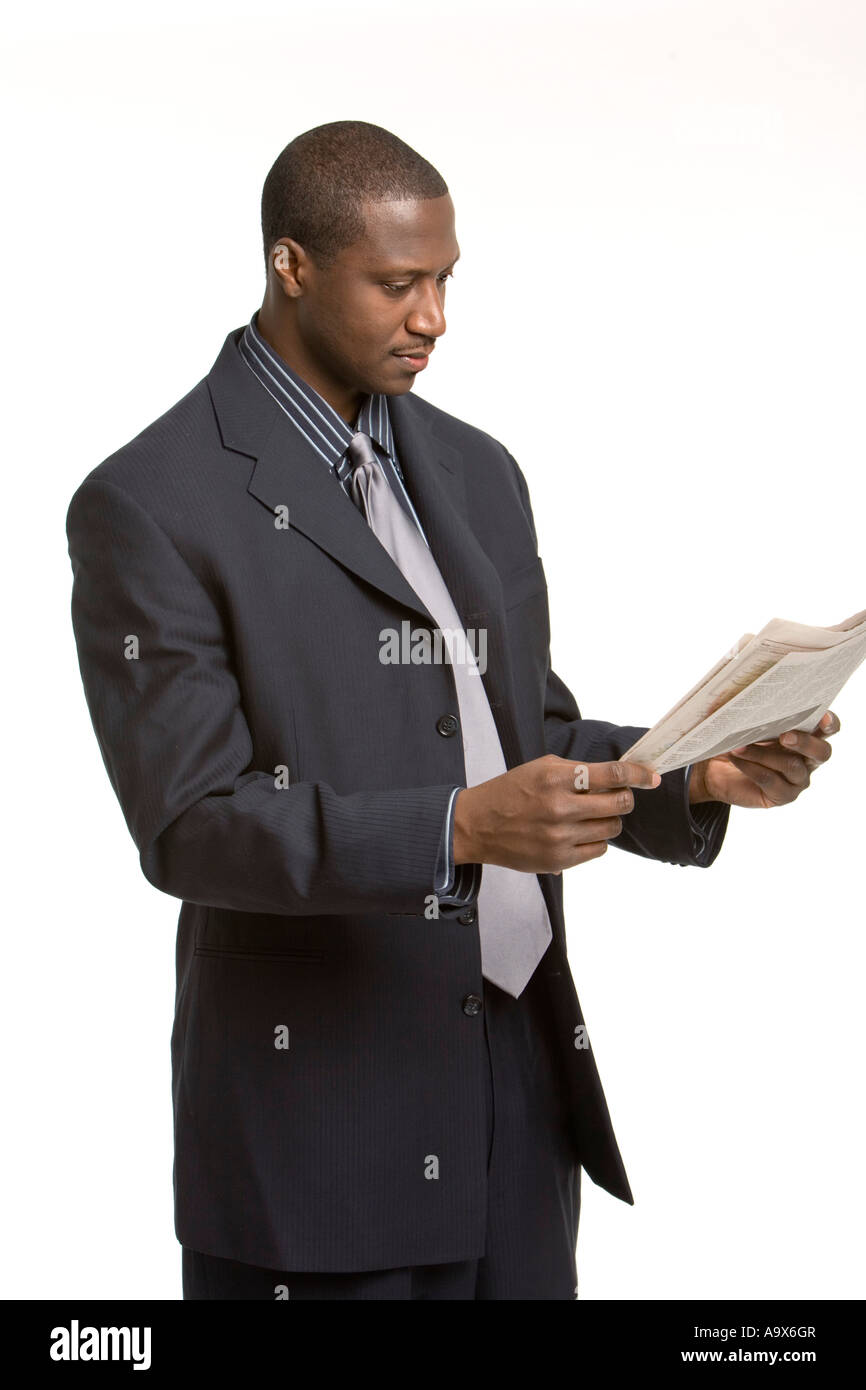 Young black business man wearing a suit and tie and reading a newspaper ...