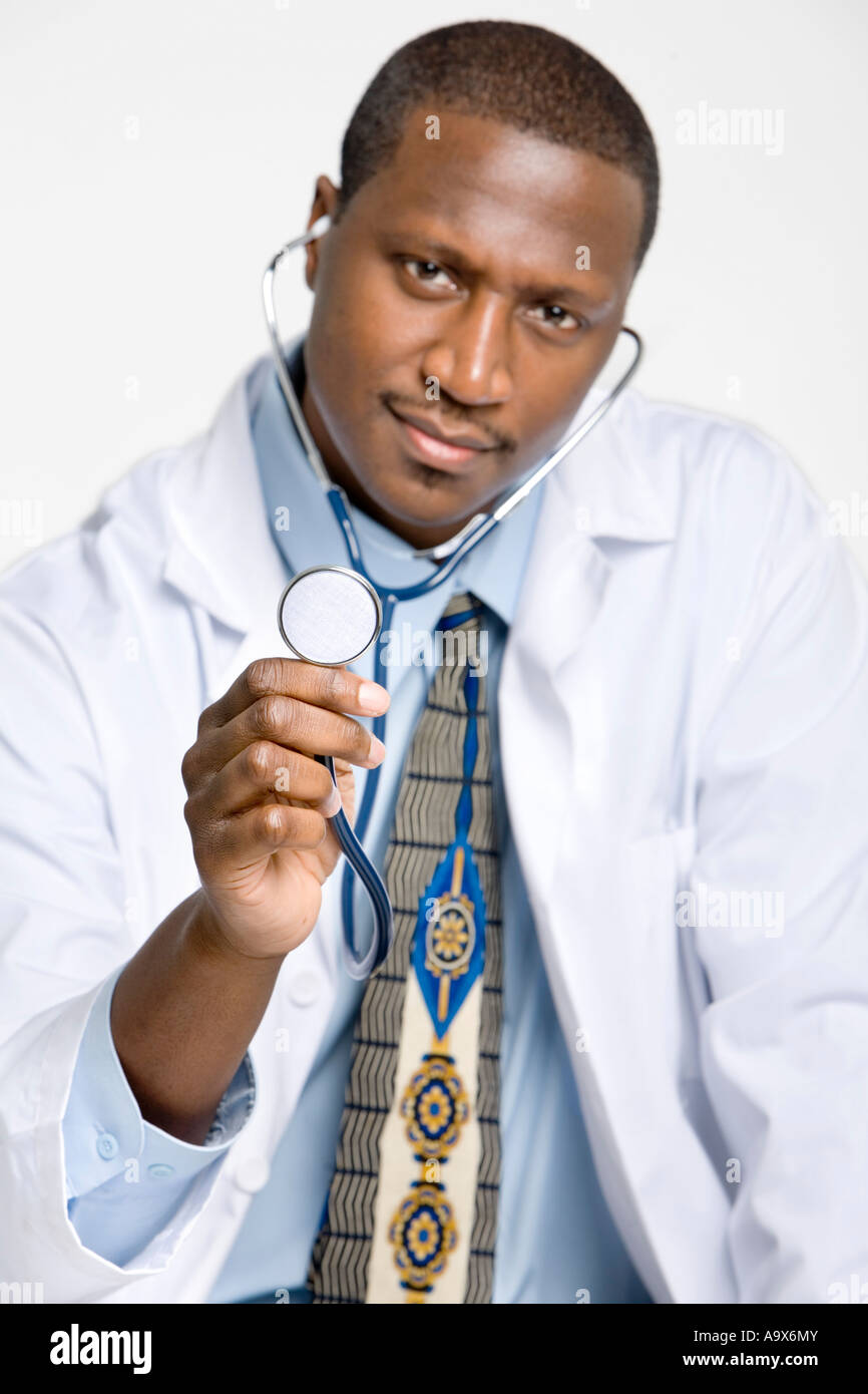 Young black doctor in a white coat holds up a stethoscope Stock Photo -  Alamy