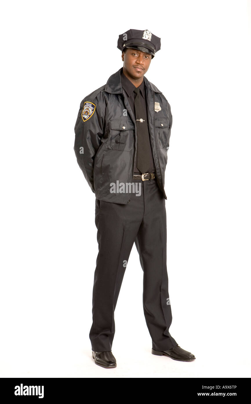 Black American police officer standing with his hands behind his back looking at the camera Stock Photo