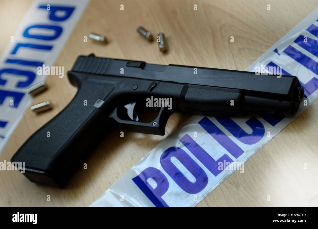 a glock17L lightweight pistol gun surrounded by police tape (Replica gun Alamy
