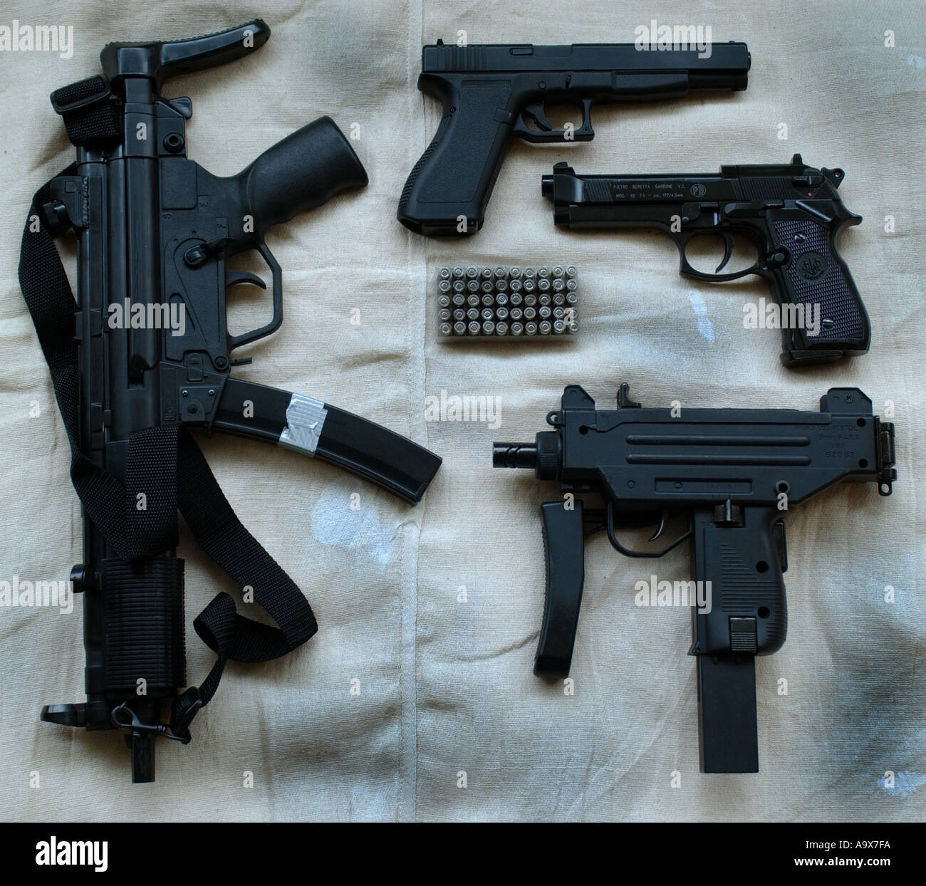 a selection of handguns including an uzi sub machinegun an heckler and koch MP5 machinegun beretta and glock 17L pistols Stock Photo
