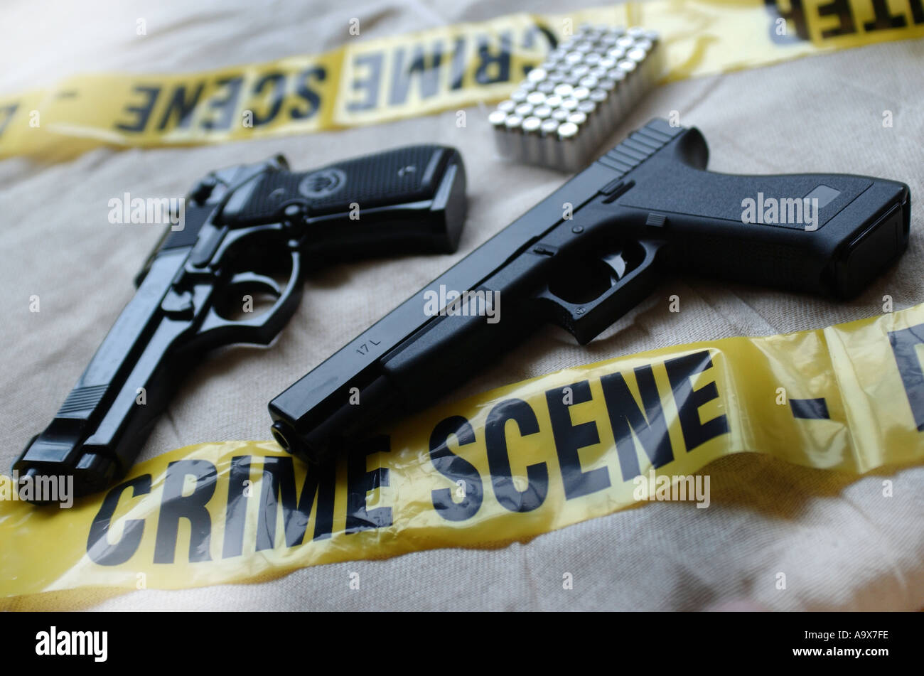 beretta and glock 17l handguns surrounded by police tape stock photo