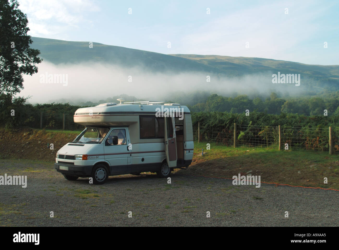 Touring Brecon Beacons National Park early morning mist clearing around VW camper van on caravan club site mains electricity hook up South Wales UK Stock Photo