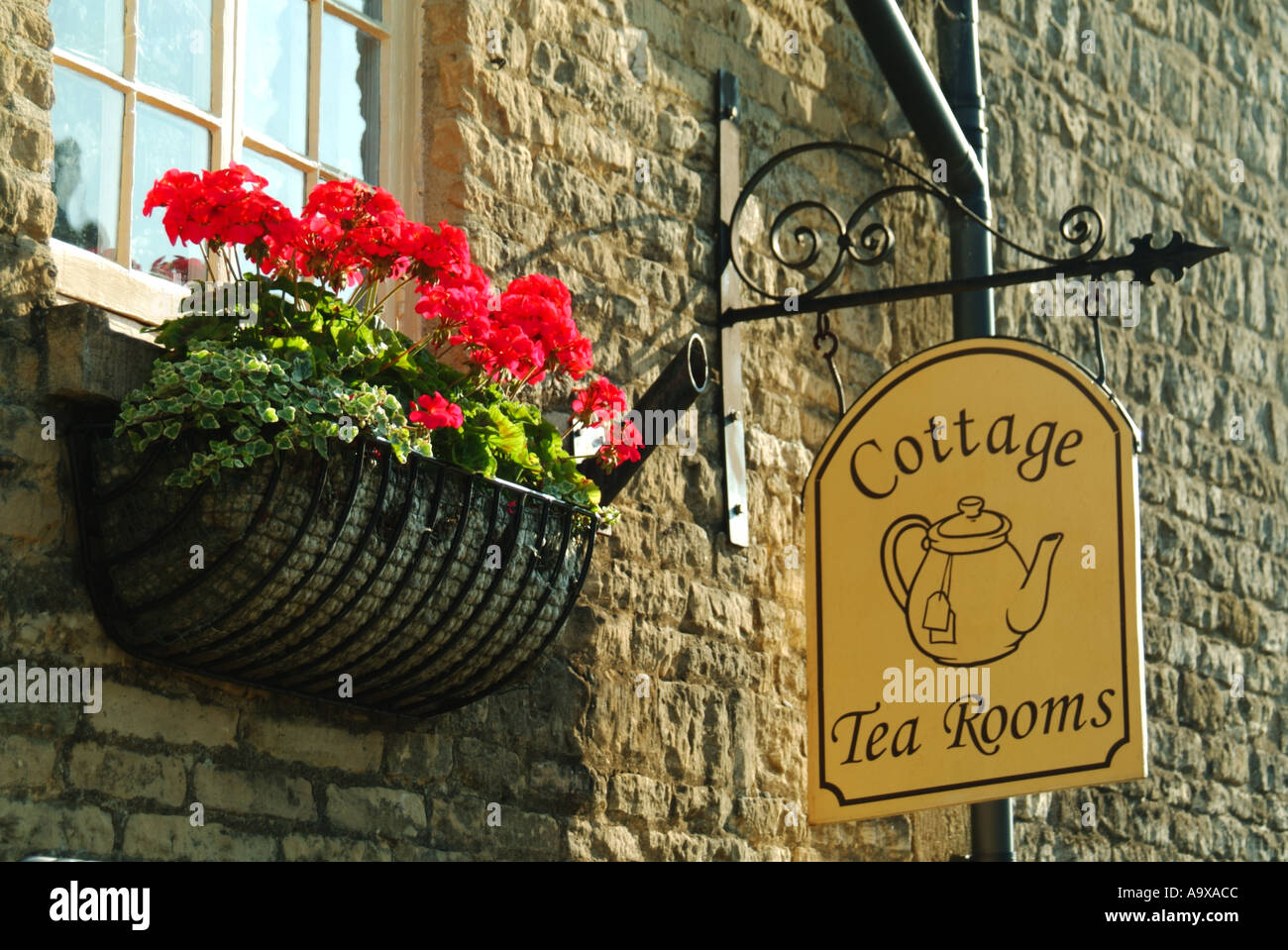 Stow on the Wold cottage tea room sign hangs from mellow stone wall