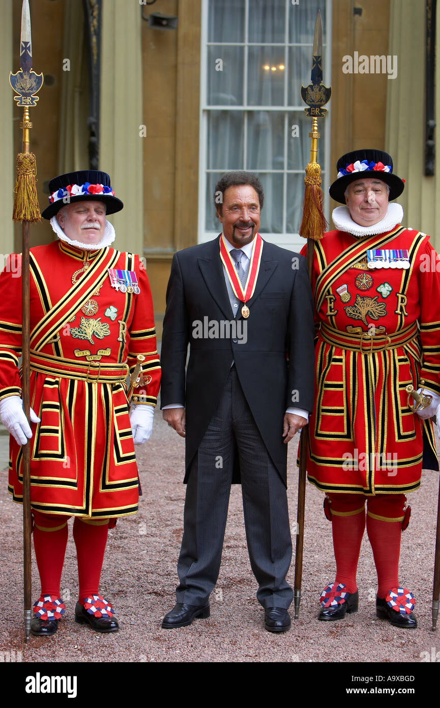 sir tom jones at buckingham palace stands next to 2 beefeaters from th tower of london Stock Photo